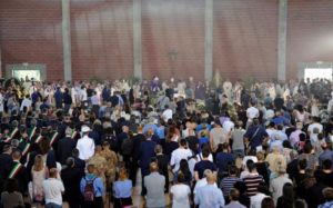 People gather during a funeral service for victims of the earthquake inside a gym in Ascoli Piceno
