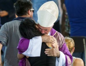 Giovanni D'Ercole, bishop of Ascoli Piceno, hugs a woman after a funeral service for victims of the earthquake inside a gym, Italy